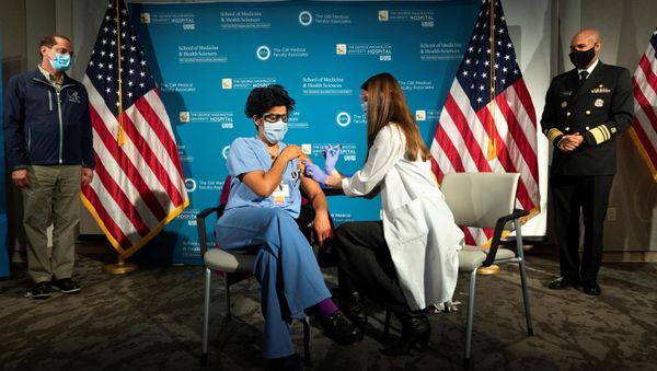 Health and Human Services Secretary Alex Azar and U.S. Surgeon General Dr. Jerome Adams watch as Dr. Sheetal Sheth OB-GYN and Medical Director for Labor and Delivery at George Washington University Hospital, is vaccinated for COVID-19 by nurse Lillian Wirpsza, in Washington, D.C., U.S. December 14, 2020. - Sputnik International