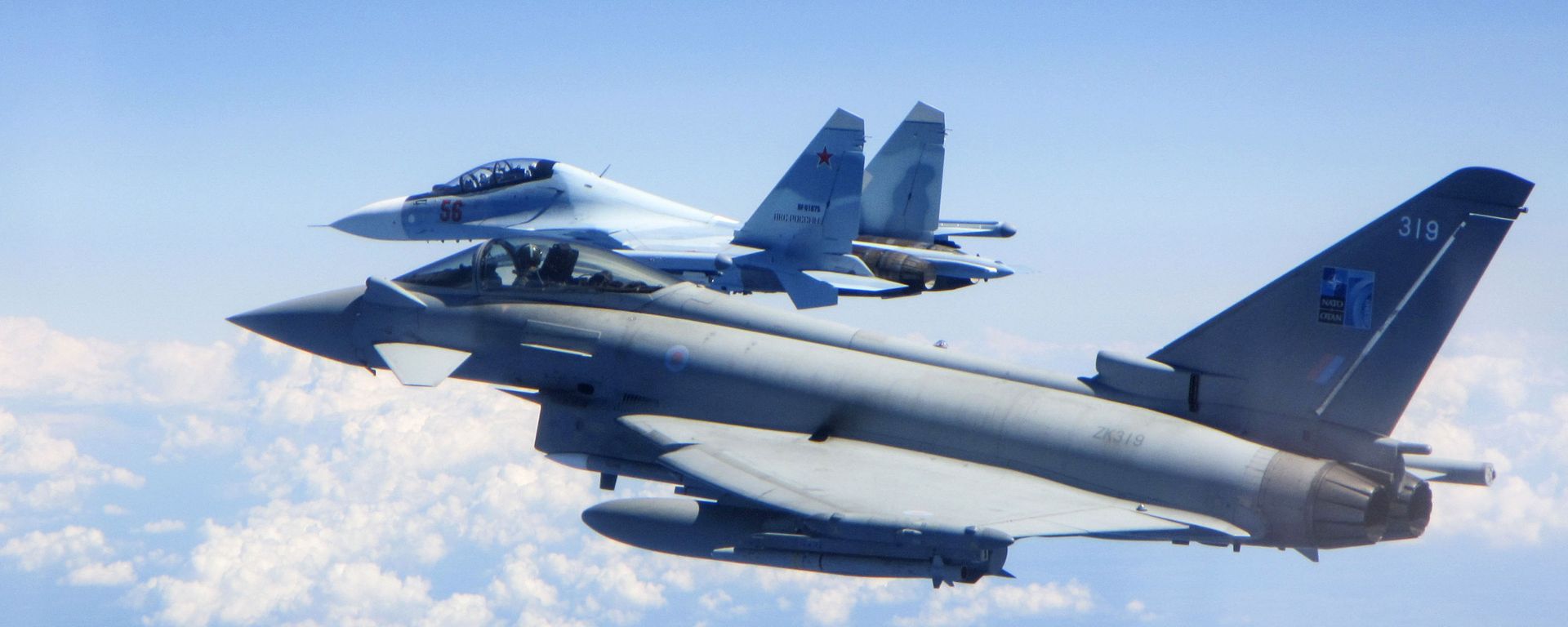 In this photo taken on Saturday, June 15, 2019, a Royal Air Force Typhoon jet, foreground, flies by a Su-30 Flanker fighter. - Sputnik International, 1920, 15.12.2020