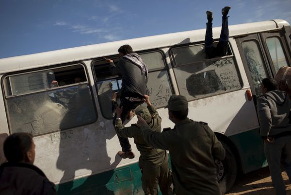 Egyptians try to board a bus as a Tunisian Army soldier tries to stop one of them, at the Tunisia-Libya border, in Ras Ajdir, Tunisia, Thursday, 3 March 2011 Egyptians try to board a bus as a Tunisian Army soldier tries to stop one of them, at the Tunisia-Libya border, in Ras Ajdir, Tunisia, Thursday, 3 March 2011 - Sputnik International