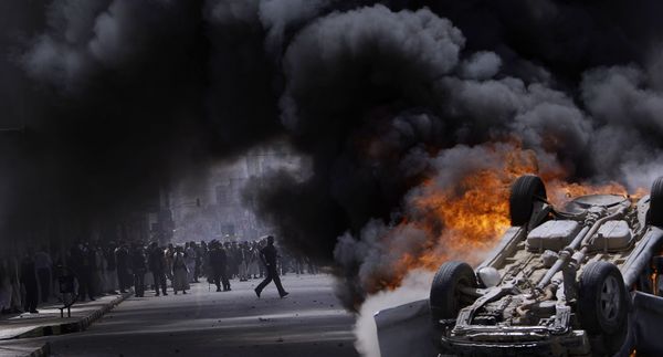 Supporters of the Yemeni government seen through the smoke of a burning vehicle that was destroyed and set on fire by anti-government demonstrators during clashes in Sanaa, Yemen, Tuesday, 22 February 2011 Supporters of the Yemeni government seen through the smoke of a burning vehicle that was destroyed and set on fire by anti-government demonstrators during clashes in Sanaa, Yemen, Tuesday, 22 February 2011 - Sputnik International