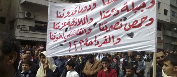 In this citizen journalism image made on a mobile phone and acquired by the AP, Syrian anti-government protesters carry a banner in Arabic that reads: Daraa is our torch, Douma is our model, Jabla is our support, Latakia is our pride, Homs is our victory, in Qamishli our brothers and what about Qardaha ??!, knowing that Qardaha is the home village of Syrian President Bashar Assad, as they gather in the coastal city of Banias, Syria, Friday, April 22, 2011 In this citizen journalism image made on a mobile phone and acquired by the AP, Syrian anti-government protesters carry a banner in Arabic that reads: Daraa is our torch, Douma is our model, Jabla is our support, Latakia is our pride, Homs is our victory, in Qamishli our brothers and what about Qardaha ??!, knowing that Qardaha is the home village of Syrian President Bashar Assad, as they gather in the coastal city of Banias, Syria, Friday, April 22, 2011 - Sputnik International