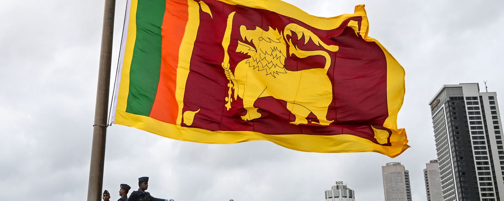 Soldiers stand at attention as the national flag is lowered as part of a daily ceremony at the Galle Face Green promenade in Colombo on May 17, 2020. Soldiers stand at attention as the national flag is lowered as part of a daily ceremony at the Galle Face Green promenade in Colombo on May 17, 2020. - Sputnik International, 1920, 17.12.2020