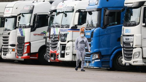 A driver wearing a face mask walks past lorries at Ashford International Truck Stop, as EU countries impose a travel ban from the UK following the coronavirus disease (COVID-19) outbreak, in Ashford, Britain 22 December 2020. - Sputnik International