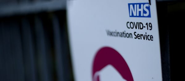 A sign is seen outside a surgery in Wolverhampton, Britain  that is delivering the Pfizer-BioNTech COVID-19 vaccine, 14 December 2020 - Sputnik International