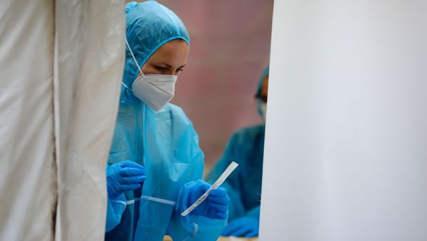A medical worker is seen at a walk-in COVID-19 testing centre of the nightclub KitKat-Club, amid the coronavirus disease (COVID-19) pandemic, in Berlin, Germany, December 23, 2020.  - Sputnik International