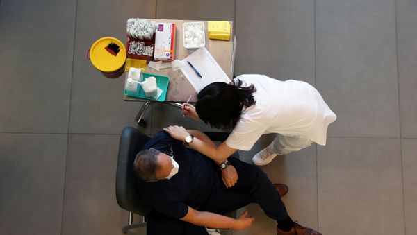 A medical worker vaccinates a man against the coronavirus disease (COVID-19) as Israel kicks off a coronavirus vaccination drive, at Tel Aviv Sourasky Medical Center (Ichilov Hospital) in Tel Aviv, Israel December 20, 2020. - Sputnik International