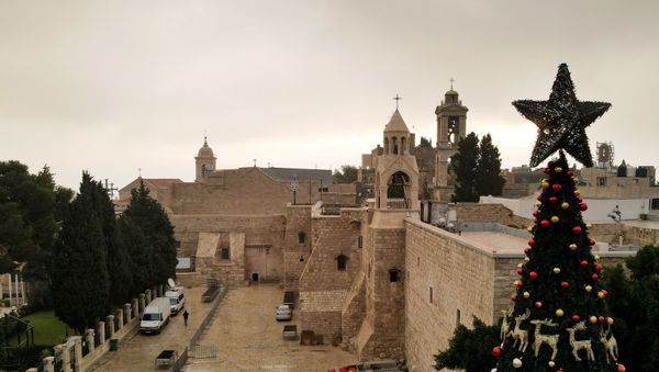 A picture taken with a drone shows the Church of the Nativity and a Christmas tree at Manger Square on Christmas Eve, in Bethlehem in the Israeli-occupied West Bank 24 December, 2020. - Sputnik International