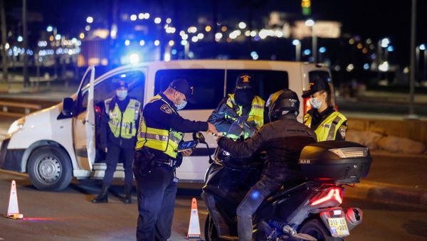 Police officers check documents of a driver at a police checkpoint, as Israel imposes a third national lockdown to fight climbing coronavirus disease (COVID-19) infections, in Tel Aviv, Israel December 27, 2020. - Sputnik International
