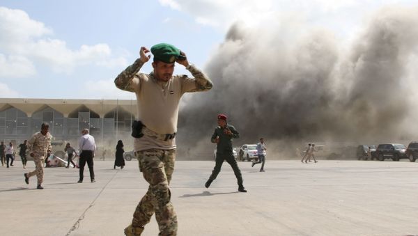 A security personnel member reacts as dust rises after explosions hit Aden airport, upon the arrival of the newly-formed Yemeni government in Aden, Yemen December 30, 2020 - Sputnik International
