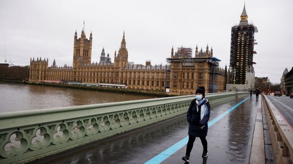 A woman wearing a face mask walks across Westminster Bridge past the Houses of Parliament, as the spread of the coronavirus disease (COVID-19) continues, in London, Britain, December 22, 2020 - Sputnik International