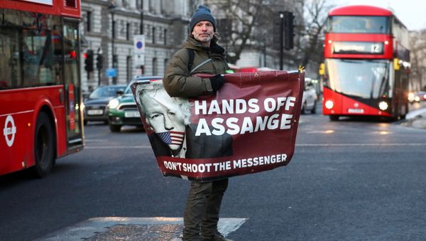 A man rides a skateboard holding a banner with an image of Julian Assange in London, Britain, December 30, 2020 A man rides a skateboard holding a banner with an image of Julian Assange in London, Britain, December 30, 2020 - Sputnik International