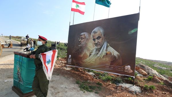 A member of Lebanon's Hezbollah holds a Lebanese flag as he stands in front of a picture depicting senior Iranian military commander General Qassem Soleimani and Iraqi militia commander Abu Mahdi al-Muhandis who were killed in a U.S. attack, during a ceremony marking the first anniversary of their killing, in the southern village of Khiam, Lebanon January 3, 2021. REUTERS/Aziz Taher A member of Lebanon's Hezbollah holds a Lebanese flag as he stands in front of a picture depicting senior Iranian military commander General Qassem Soleimani and Iraqi militia commander Abu Mahdi al-Muhandis who were killed in a U.S. attack, during a ceremony marking the first anniversary of their killing, in the southern village of Khiam, Lebanon January 3, 2021. REUTERS/Aziz Taher - Sputnik International