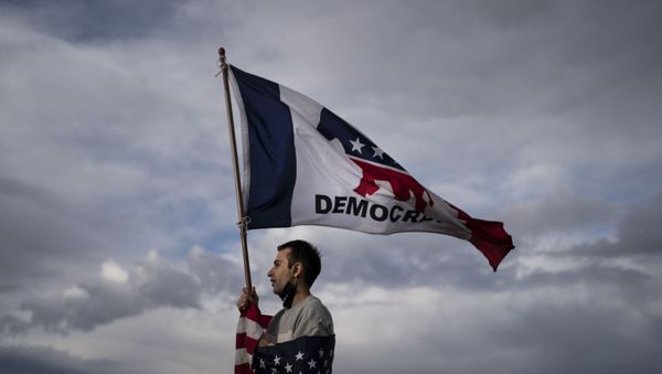 A lone Biden supporter stands outside of the Clark County Elections Department in North Las Vegas, Saturday, Nov. 7, 2020. - Sputnik International
