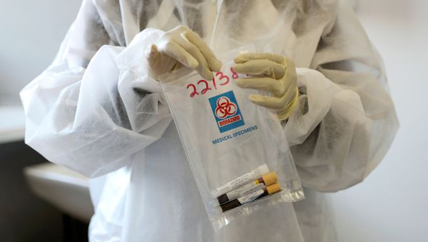 A health worker holds a COVID-19 sample collection kit of a vaccine trials' volunteer, after they were tested for the coronavirus disease and take part in the country's human clinical trial for potential vaccines at the Wits RHI Shandukani Research Centre in Johannesburg, South Africa, August 27, 2020. - Sputnik International