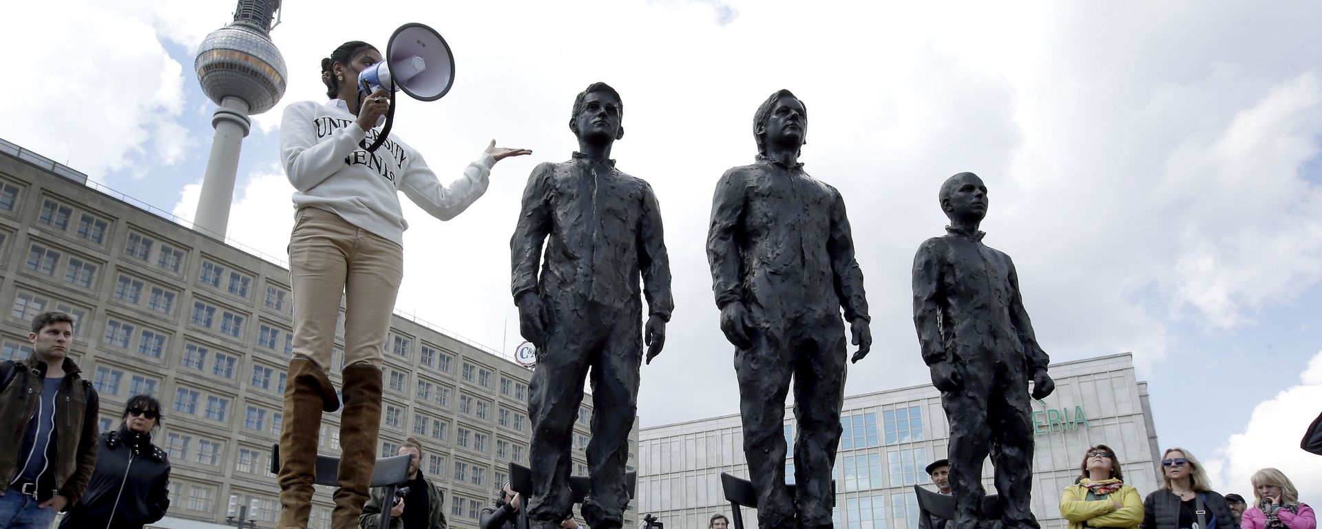 A woman delivers a speech as she stands on a chair of the public art project Anything to Say? at the Alexander Square in Berlin, Germany, Friday, May 1, 2015. The sculpture of the Italian artist Davide Dormino shows the whistleblowers Chelsea Manning, Julian Assange and Edward Snowden, from right, to honour their courage. (AP Photo/Michael Sohn) A woman delivers a speech as she stands on a chair of the public art project Anything to Say? at the Alexander Square in Berlin, Germany, Friday, May 1, 2015. The sculpture of the Italian artist Davide Dormino shows the whistleblowers Chelsea Manning, Julian Assange and Edward Snowden, from right, to honour their courage. (AP Photo/Michael Sohn) - Sputnik International, 1920, 21.02.2024