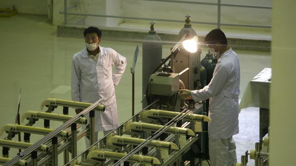 In this April 9, 2009 file picture Iranian technicians work  at a new facility producing uranium fuel for a planned heavy-water nuclear reactor, just outside the city of Isfahan, 255 miles (410 kilometers) south of the capital Tehran. Iran is lagging behind on equipping a bunker with machines enriching uranium to a grade that can be turned quickly to arm nuclear warheads and now says will produce less at the site than originally planned, diplomats tell The Associated Press.   - Sputnik International