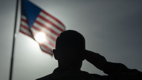 In this photo taken Aug. 26, 2019 and released by the U.S. Air Force, U.S. Air Force Staff Sgt. Devin Boyer, 435th Air Expeditionary Wing photojournalist, salutes the flag during a ceremony signifying the change from tactical to enduring operations at Camp Simba, Manda Bay, Kenya - Sputnik International