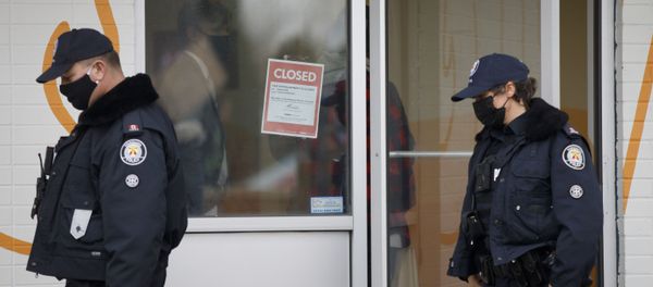 Toronto Police officers walk by a shutdown order on the window of Adamson Barbecue, an Etobicoke business that has defied provincial shutdown orders, on November 25, 2020 in Toronto, Canada. - Sputnik International