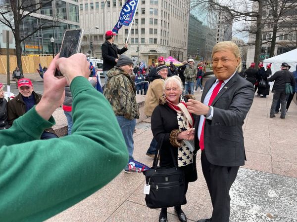 A demonstrator takes a selfie with a person wearing a Trump mask during a rally in Washington DC. A demonstrator takes a selfie with a person wearing a Trump mask during a rally in Washington DC. - Sputnik International