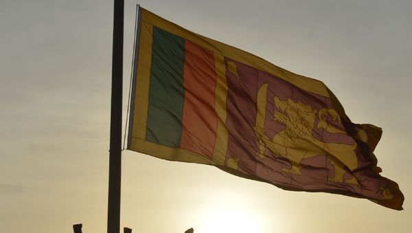 Sri Lankan soldiers stand at attention as their national flag is lowered as part of a daily ceremony at the Galle Face Green promenade in Colombo on July 20, 2018.  - Sputnik International
