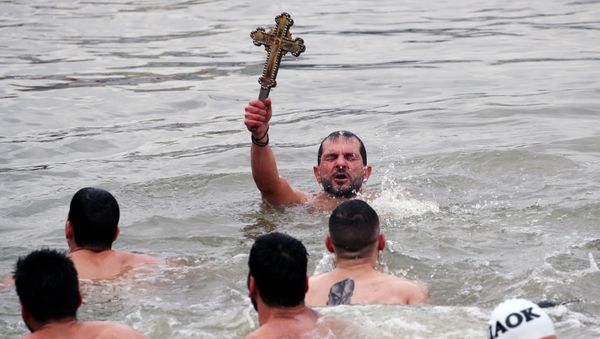  Greek Orthodox faithful Michalis Vosnauidis, a pilgrim from Thessaloniki, Greece, retrieves a wooden crucifix as he swims in the Golden Horn during the Epiphany ceremony in Istanbul, Turkey, January 6, 2019.  - Sputnik International