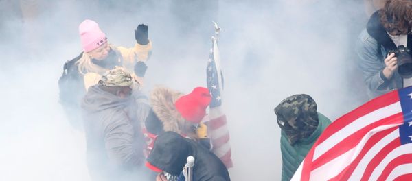 Pro-Trump protesters react amidst a cloud of tear gas during clashes with Capitol police at a rally to contest the certification of the 2020 US presidential election results by the US Congress, at the US Capitol Building in Washington, US, January 6, 2021. REUTERS/Shannon Stapleton - Sputnik International