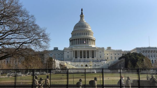 National Guard members walk behind a fence installed in front of the U.S. Capitol, a day after supporters of U.S. President Donald Trump occupied the Capitol building, in Washington, U.S. January 7, 2021. - Sputnik International