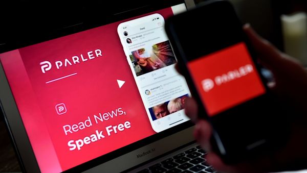 (FILES) In this file photo taken on July 01, 2020 an illustration picture shows social media application logo from Parler displayed on a smartphone with its website in the background in Arlington, Virginia. - Apple on January 9, 2021 - Sputnik International