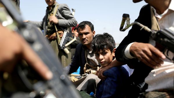 A boy rides with Houthi followers on the back of a patrol truck during the funeral of Houthi fighters - Sputnik International