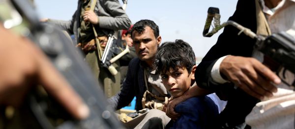 A boy rides with Houthi followers on the back of a patrol truck during the funeral of Houthi fighters - Sputnik International