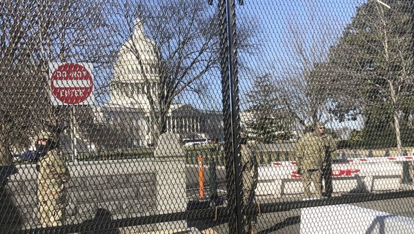 Members of the National Guard stand inside anti-scaling fencing that surrounds the Capitol, Sunday, Jan. 10, 2021, in Washington - Sputnik International