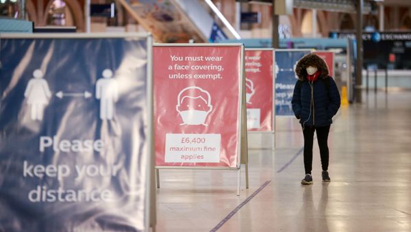 A commuter walks past information boards at Waterloo station during morning rush hour, amid the coronavirus disease (COVID-19) outbreak, in London, Britain, January 5, 2021 - Sputnik International