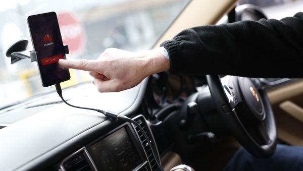A man shows the Huawei Mate 10 Pro smartphone able to drive a Porsche Panamera car during its presentation at the Camp Nou stadium in Barcelona on February 26, 2018 on the first day of the Mobile World Congress (MWC) - Sputnik International
