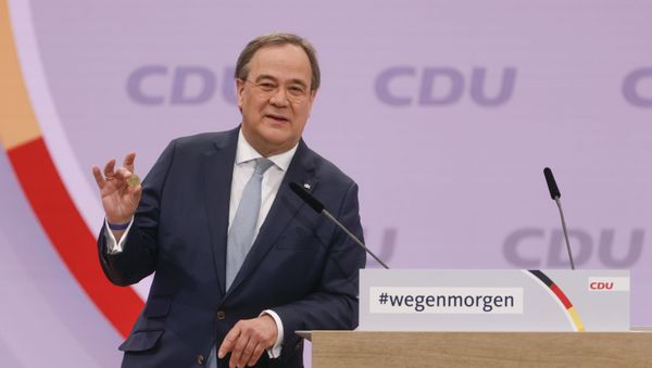 North Rhine-Westphalia's State Premier and candidate as leader of the Christian Democratic Union (CDU) Armin Laschet shows a luck coin offered to him by his father as he delivers a speech on the second day of the party's 33rd congress held online because of the coronavirus pandemic, in Berlin on January 16, 2021. - Germany's conservative CDU party will elect a new leader on on January 16, 2021, in a key vote kicking off the race for Germany's top job as a deadly pandemic roils Europe's biggest economy. - Sputnik International
