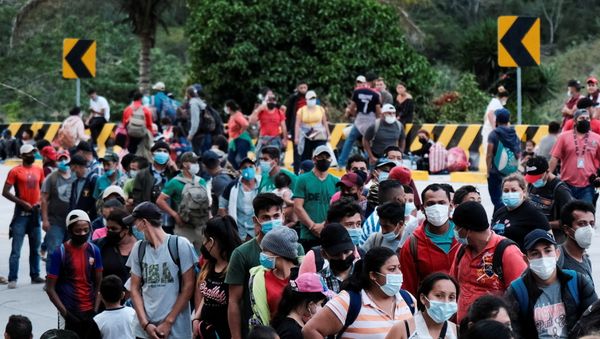 Hondurans taking part in a new caravan of migrants, set to head to the United States, queue to receive water from the Red Cross after arriving to the El Florido border crossing point with Guatemala, in El Florido, Honduras January 15, 2021.  - Sputnik International