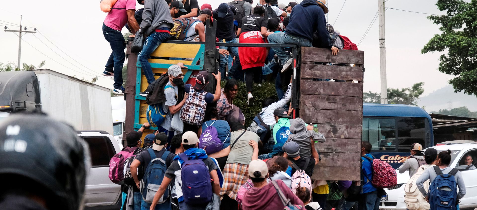 Hondurans climb onto the back of a truck for a ride in a new caravan of migrants, set to head to the United States, in Cofradia, Honduras January 15, 2021. Hondurans climb onto the back of a truck for a ride in a new caravan of migrants, set to head to the United States, in Cofradia, Honduras January 15, 2021. - Sputnik International, 1920, 18.01.2021