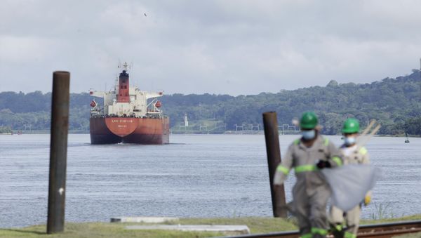 Workers in masks walk past a ship in the Panama Canal - Sputnik International