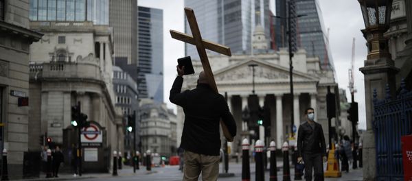 A man holding a cross and a Bible preaches about Christianity backdropped by the Royal Exchange, back center, and the Bank of England, at left, during England's second coronavirus lockdown in the City of London financial district of London, Wednesday, Nov. 18, 2020 A man holding a cross and a Bible preaches about Christianity backdropped by the Royal Exchange, back center, and the Bank of England, at left, during England's second coronavirus lockdown in the City of London financial district of London, Wednesday, Nov. 18, 2020 - Sputnik International