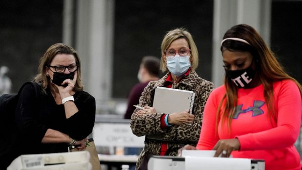 Observers watch an official work as ballots are counted for Georgia's Senate runoff election at the Georgia World Congress Center on Wednesday, Jan. 6, 2021, in Atlanta - Sputnik International