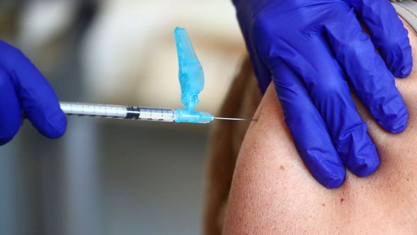 A health worker receives an injection with a dose of the Pfizer-BioNTech COVID-19 vaccine, amid the coronavirus disease (COVID-19) outbreak, at Fuentelarreina primary healthcare centre in Madrid, Spain January 18, 2021. - Sputnik International
