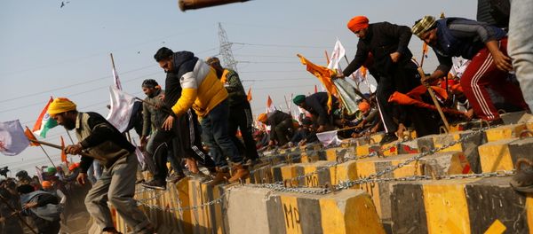 Farmers cross a barricade during a tractor rally to protest against farm laws on the occasion of India's Republic Day in Delhi, India, January 26, 2021 - Sputnik International