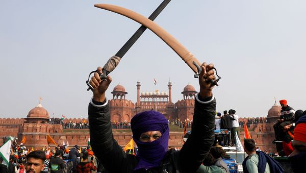 A farmer holds a sword during a protest against farm laws introduced by the government, at the historic Red Fort in Delhi, India, 26 January 2021 A farmer holds a sword during a protest against farm laws introduced by the government, at the historic Red Fort in Delhi, India, 26 January 2021 - Sputnik International
