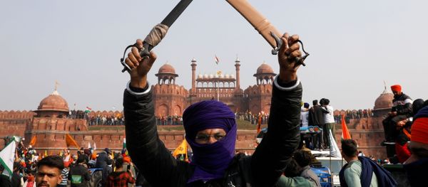 A farmer holds a sword during a protest against farm laws introduced by the government, at the historic Red Fort in Delhi, India, January 26, 2021 - Sputnik International