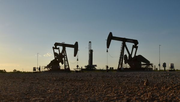 FILE PHOTO: Pump jacks operate in front of a drilling rig in an oil field in Midland - Sputnik International