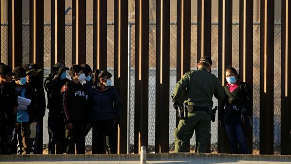 Migrants from Central America are detained by a U.S. Border Patrol agent as they turn themselves in to request asylum, after crossing into El Paso, Texas, U.S., as seen from Ciudad Juarez, Mexico January 22, 2021 - Sputnik International