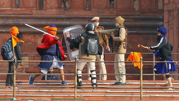 A Nihang (sikh warrior) beats a policeman with a baton during a protest against farm laws introduced by the government, at the historic Red Fort in Delhi, India, January 26, 2021 A Nihang (sikh warrior) beats a policeman with a baton during a protest against farm laws introduced by the government, at the historic Red Fort in Delhi, India, January 26, 2021 - Sputnik International