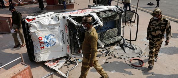 Policemen walk past a damaged police vehicle outside the historic Red Fort after Tuesday's clashes between police and farmers, in the old quarters of Delhi, India, January 27, 2021 Policemen walk past a damaged police vehicle outside the historic Red Fort after Tuesday's clashes between police and farmers, in the old quarters of Delhi, India, January 27, 2021 - Sputnik International