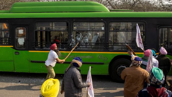 A farmer breaks windows of a government bus as during a tractor rally to protest against farm laws on the occasion of India's Republic Day in New Delhi, India, 26 January 2021. - Sputnik International