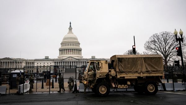 U.S. National Guard troops unload food near barbed wire and security fencing around the U.S. Capitol in Washington, U.S., January 26, 2021. REUTERS/Al Drago - Sputnik International