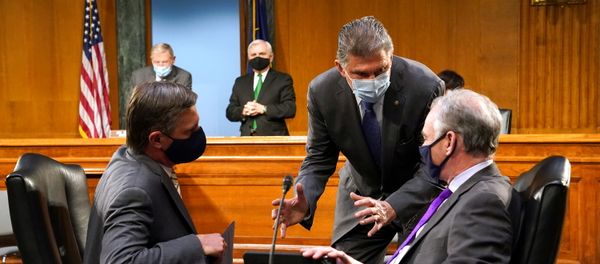 Sen. Joe Manchin (D-W.Va.) speaks to Sens. Martin Heinrich (D-N.M.) and Tim Kaine (D-Va.) prior to President-elect Joe Biden's nominee for Secretary of Defense Retired Army Gen. Lloyd Austin confirmation hearing before the Senate Armed Services Committee in Washington, U.S. January 19, 2021 - Sputnik International